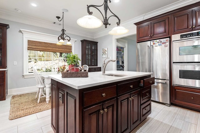 kitchen with sink, stainless steel appliances, crown molding, an island with sink, and pendant lighting