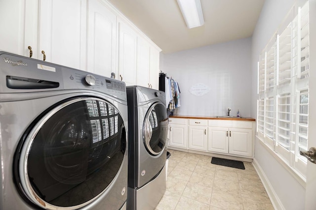 laundry room featuring light tile patterned flooring, cabinets, independent washer and dryer, and sink