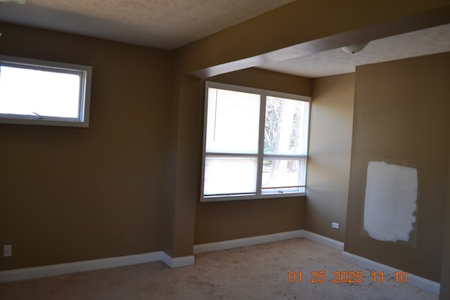 unfurnished room featuring plenty of natural light and a textured ceiling