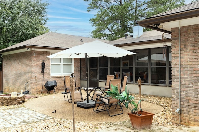 4524 Hedingham Ln, Columbus, GA 31907 - back of house featuring a patio, brick siding, a shingled roof, and an outdoor fire pit