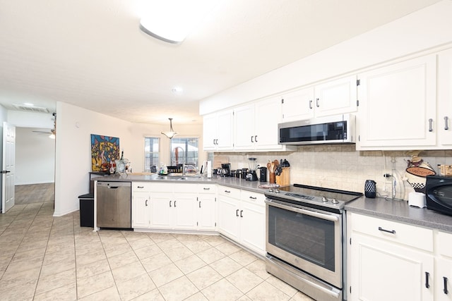 4524 Hedingham Ln, Columbus, GA 31907 - kitchen with appliances with stainless steel finishes, decorative backsplash, light tile patterned flooring, white cabinets, and a peninsula