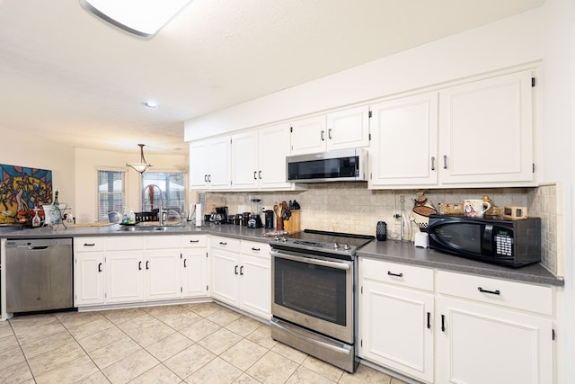 4524 Hedingham Ln, Columbus, GA 31907 - kitchen featuring appliances with stainless steel finishes, dark countertops, backsplash, white cabinets, and recessed lighting