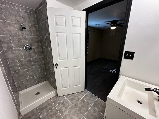 bathroom with tile patterned flooring, a tile shower, ceiling fan, and sink