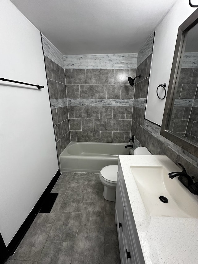 full bathroom featuring toilet, vanity, and tiled shower / bath