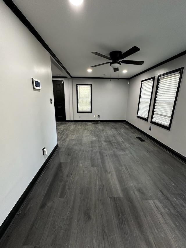 empty room featuring ceiling fan, crown molding, and dark hardwood / wood-style floors