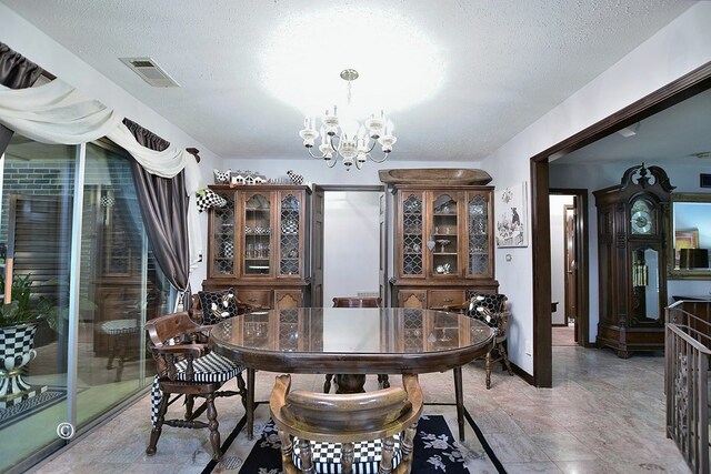 dining room with a textured ceiling and a notable chandelier