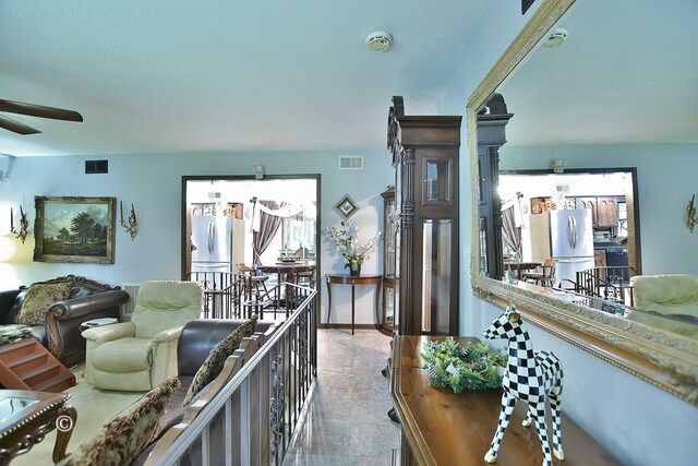 living room with a textured ceiling and ceiling fan