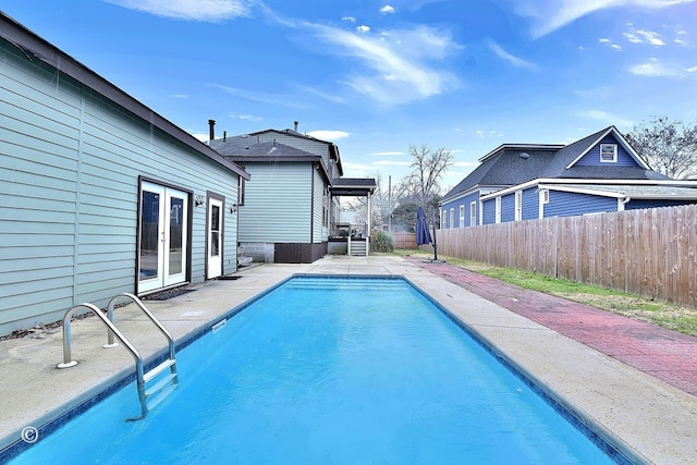 view of pool featuring french doors, a patio area, fence, and a fenced in pool