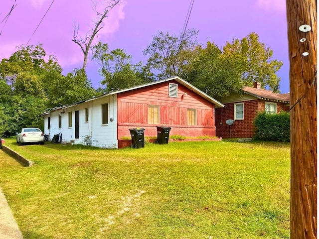 property exterior at dusk with a yard