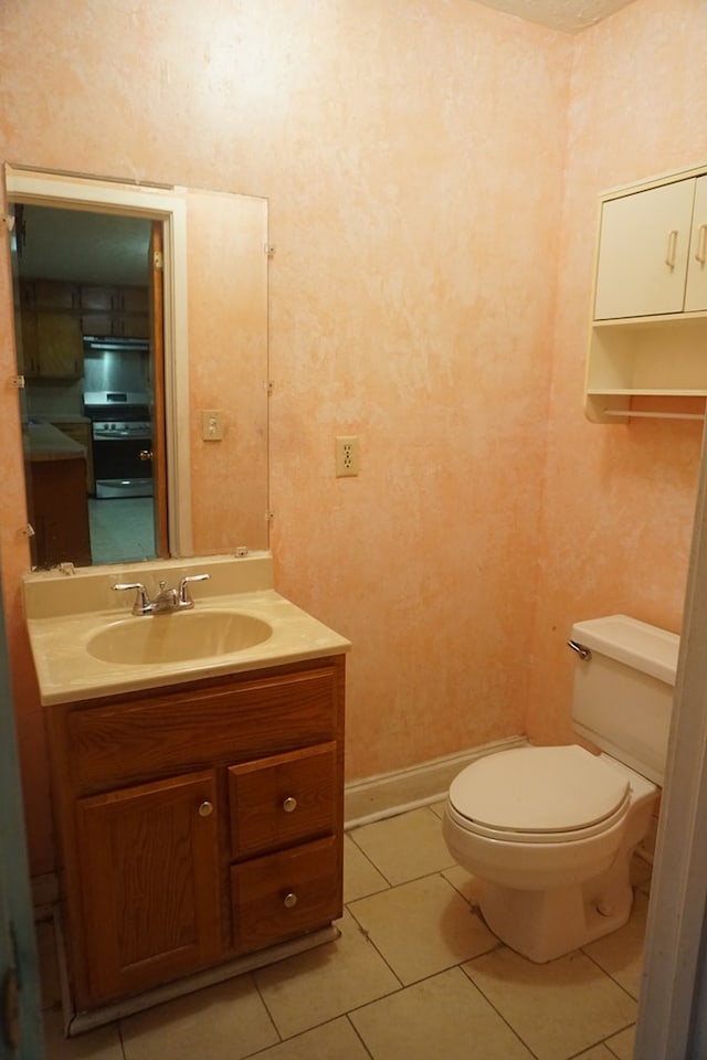 bathroom featuring tile patterned flooring, vanity, and toilet