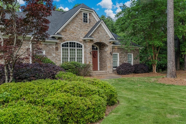 view of front of property with a front lawn and stone siding