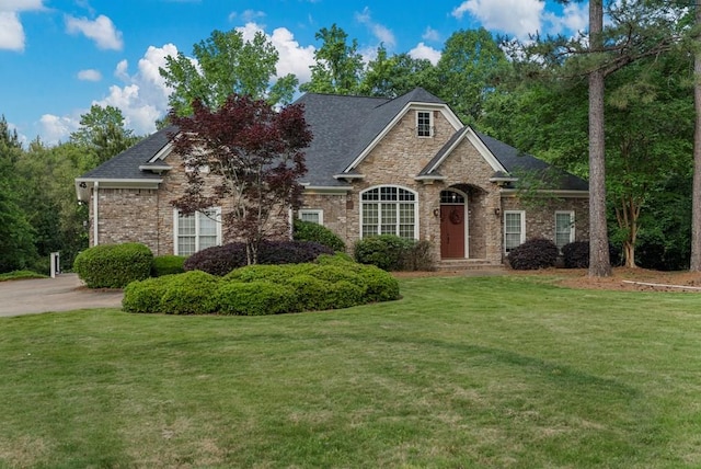 view of front of house with brick siding, a front lawn, and stone siding