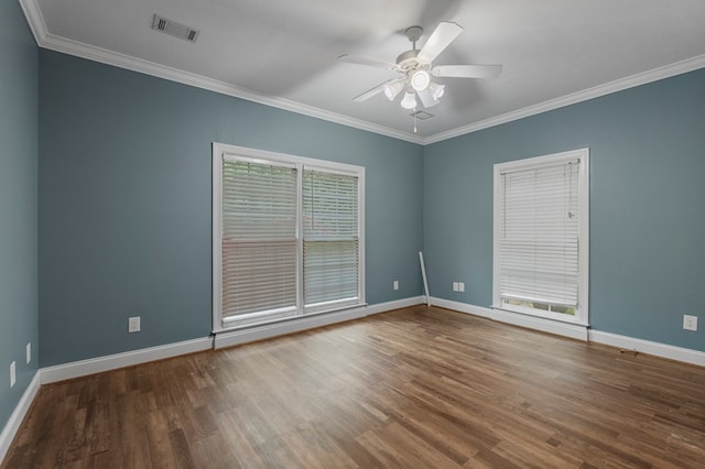 spare room featuring visible vents, ornamental molding, wood finished floors, baseboards, and ceiling fan