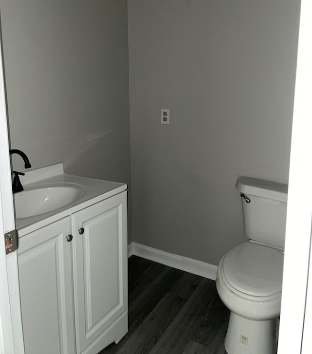 bathroom with vanity, toilet, and wood-type flooring