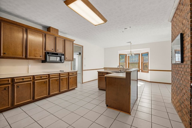 kitchen with brown cabinets, light tile patterned floors, a sink, and black appliances