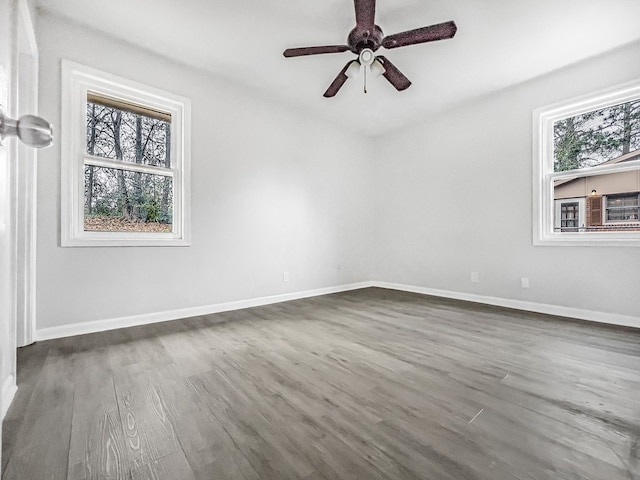 empty room with baseboards, dark wood finished floors, and a ceiling fan