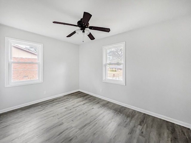 unfurnished room with ceiling fan, wood finished floors, and baseboards