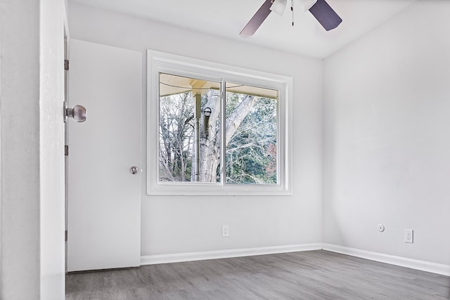 unfurnished room with ceiling fan, wood finished floors, and baseboards