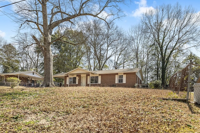 view of front of home featuring a carport, brick siding, and fence