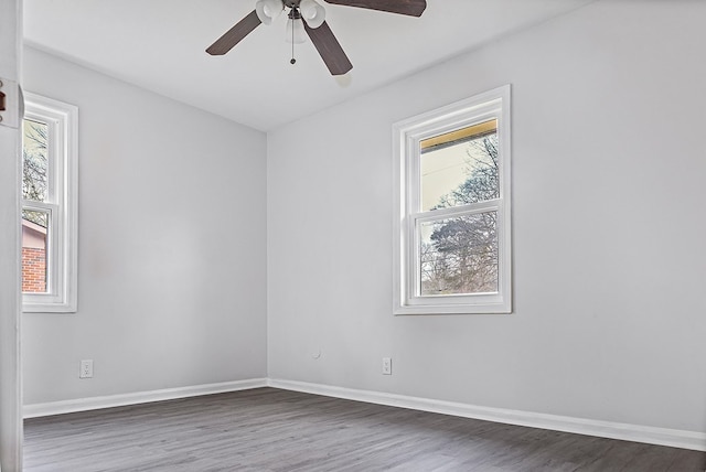 spare room featuring a healthy amount of sunlight, baseboards, and wood finished floors