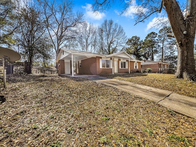 view of front of home with driveway and brick siding