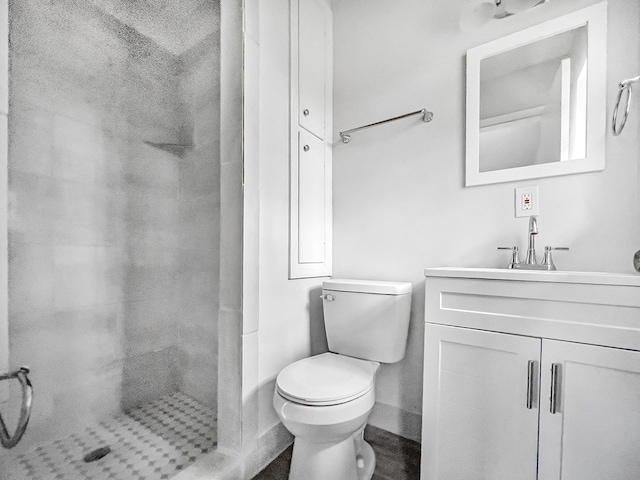 bathroom featuring a shower stall, toilet, and vanity