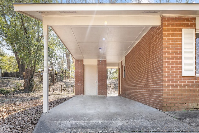 view of patio featuring an attached carport and fence