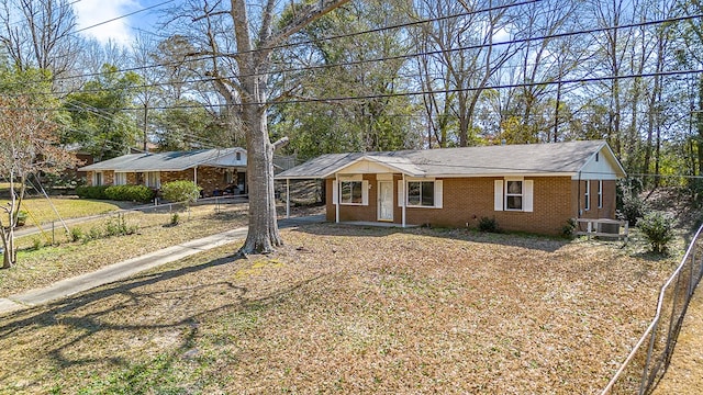 single story home with fence, an attached carport, and brick siding