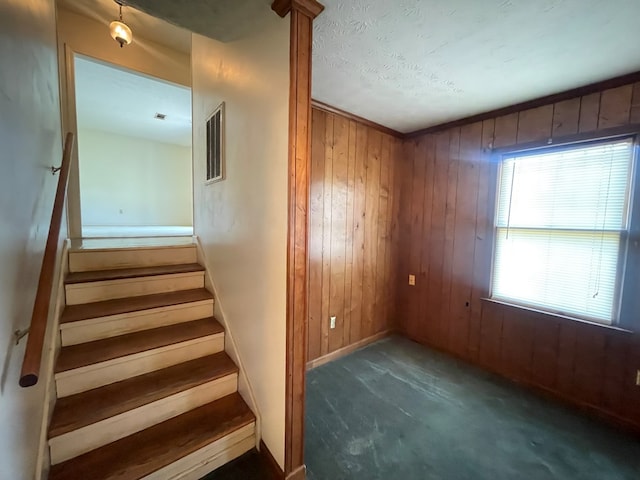 4200 Curry St, Columbus, GA 31907 - staircase with wood walls, carpet flooring, and a textured ceiling