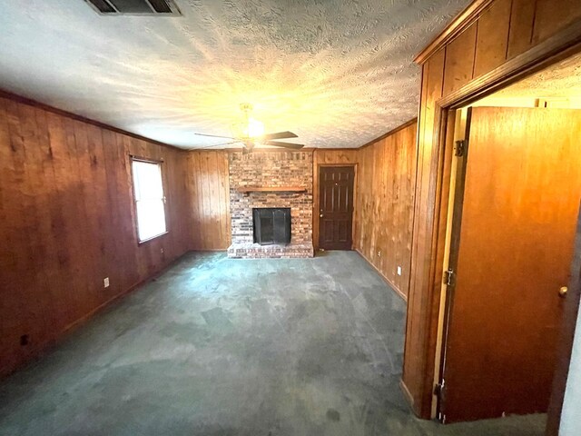 4200 Curry St, Columbus, GA 31907 - unfurnished living room with a ceiling fan, wooden walls, a fireplace, carpet, and a textured ceiling