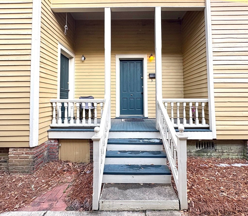 view of exterior entry featuring covered porch