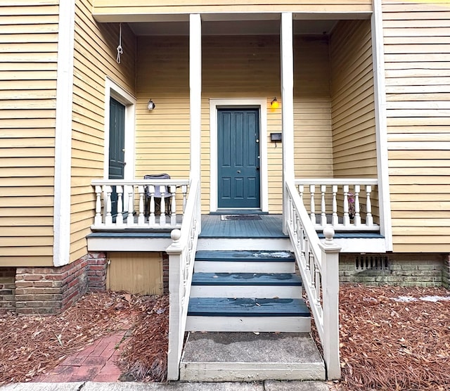 view of exterior entry featuring covered porch