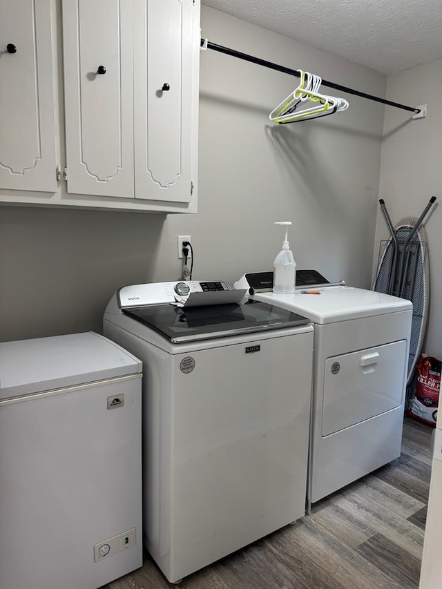 4901 Willowbrook Dr, Columbus, GA 31909 - laundry room featuring washing machine and dryer, cabinet space, light wood-style floors, and a textured ceiling
