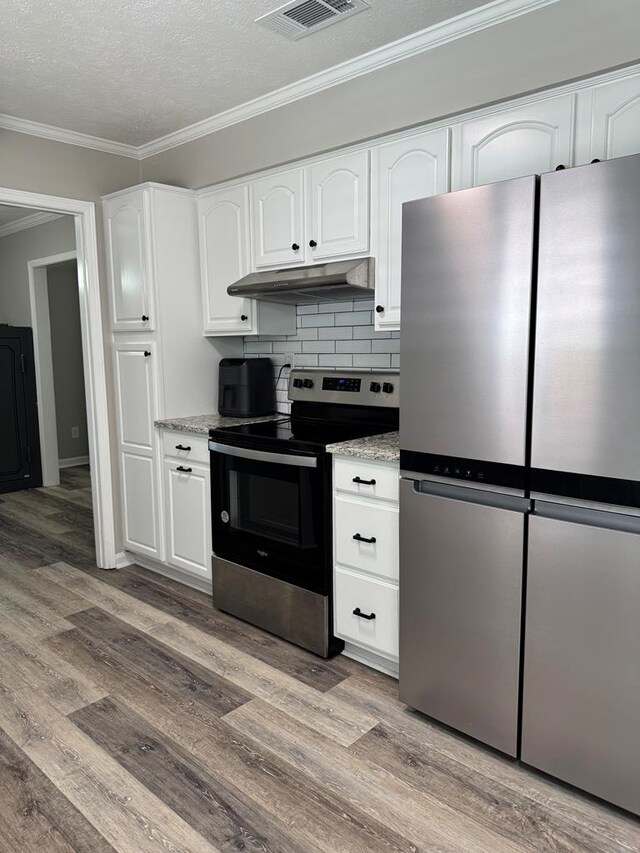 4901 Willowbrook Dr, Columbus, GA 31909 - kitchen with stainless steel appliances, under cabinet range hood, light wood-style flooring, white cabinetry, and ornamental molding