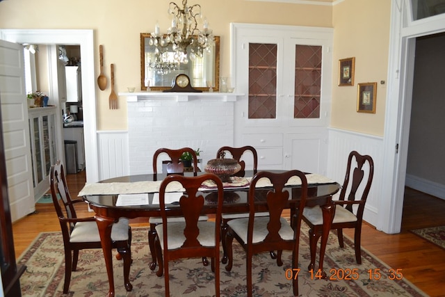 2901 Beacon Ave, Columbus, GA 31904 - dining space with wainscoting, light wood-type flooring, french doors, and a chandelier