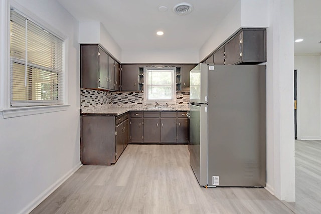 4657 Pate Dr, Columbus, GA 31907 - kitchen featuring decorative backsplash, open shelves, light wood-style floors, dark brown cabinets, and freestanding refrigerator