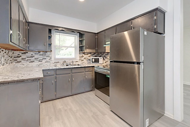 4657 Pate Dr, Columbus, GA 31907 - kitchen featuring a sink, decorative backsplash, stainless steel appliances, light wood-style floors, and open shelves