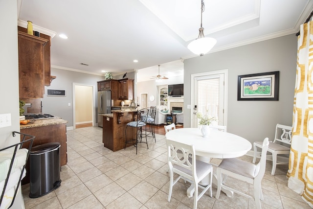 dining area with a ceiling fan, recessed lighting, a fireplace, crown molding, and light tile patterned floors