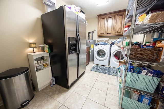 laundry room with light tile patterned floors, cabinet space, and washing machine and clothes dryer