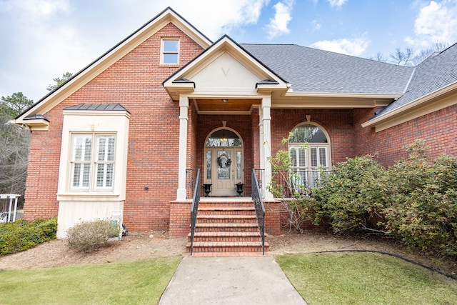 view of front of home with brick siding and a shingled roof