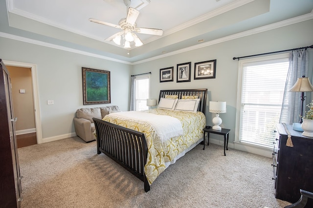 carpeted bedroom with crown molding and a tray ceiling