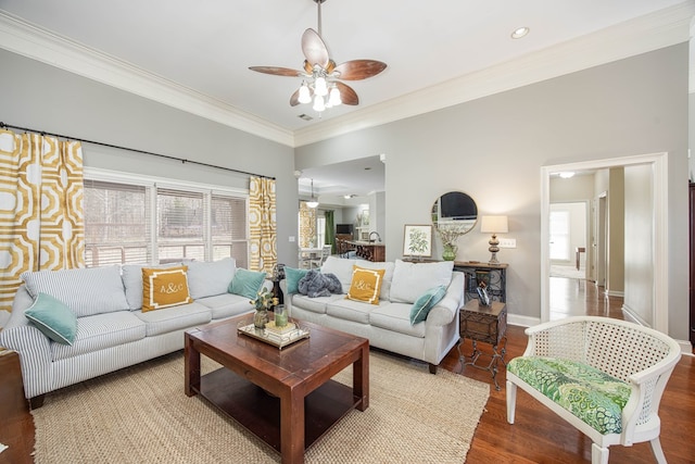 living room featuring wood finished floors, a ceiling fan, baseboards, and ornamental molding