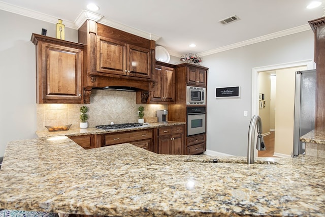 kitchen with light stone counters, visible vents, appliances with stainless steel finishes, crown molding, and backsplash