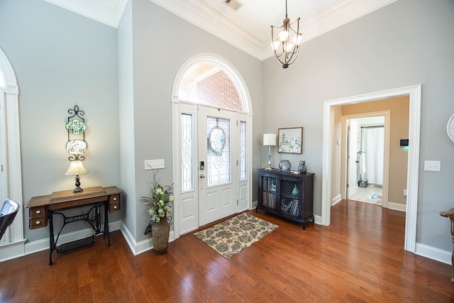 foyer entrance with crown molding, baseboards, a chandelier, a high ceiling, and wood finished floors