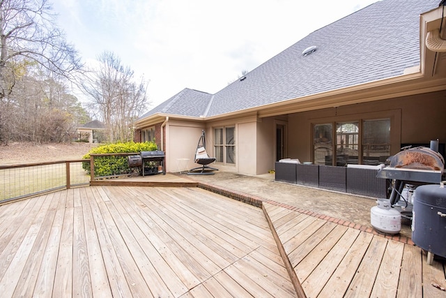 wooden deck with area for grilling and an outdoor hangout area