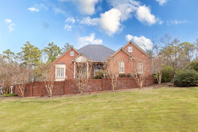 view of front of house with a front yard and brick siding