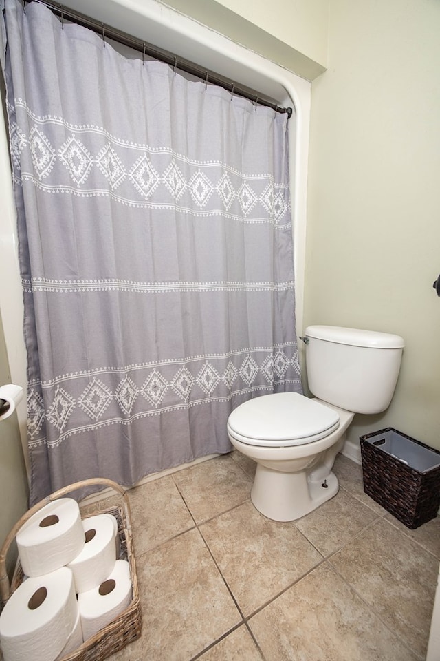 bathroom with tile patterned floors, a shower with curtain, and toilet