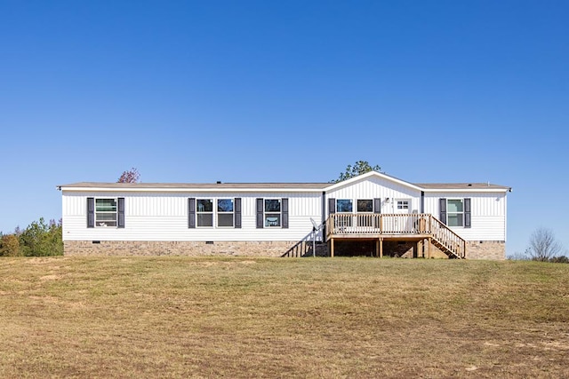 rear view of house with a wooden deck and a yard