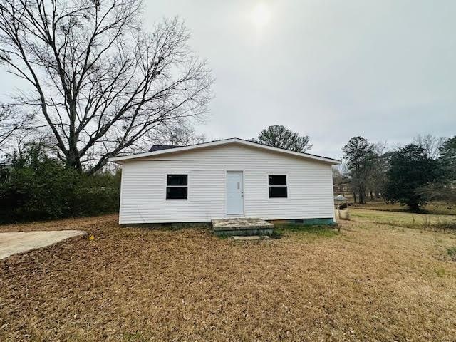 rear view of house featuring a lawn