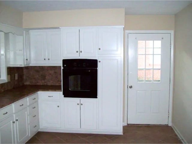 920 Ashland Ave, Columbus, GA 31907 - kitchen featuring oven, white cabinetry, decorative backsplash, and dark tile patterned floors
